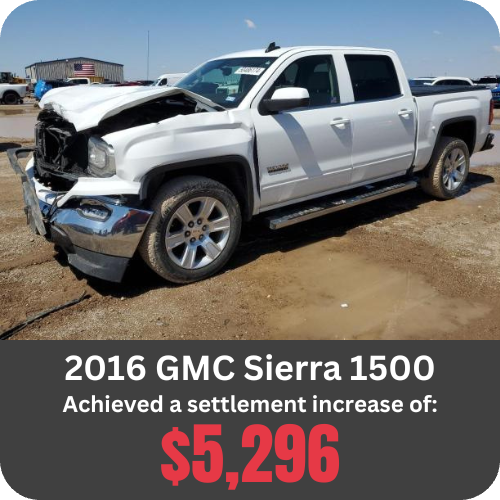 2016 GMC Sierra 1500 pickup with heavy front-end collision damage, parked in a salvage yard.